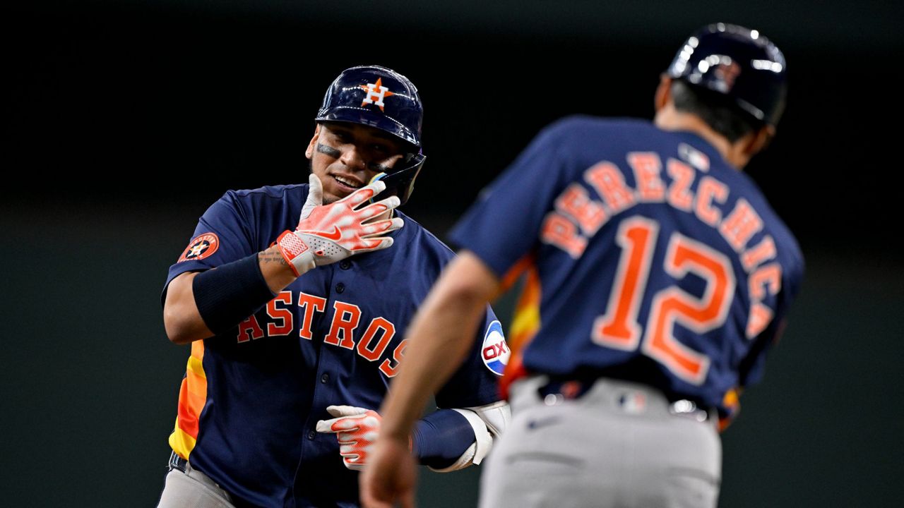 Houston Astros' Isaac Paredes, left, rounds the bases past third base coach Tony Perezchica (12) after hitting a three-run home run off Texas Rangers relief pitcher Robert Garcia during the eighth inning of a baseball game in Arlington, Texas, Sunday, May 18, 2025. (AP Photo/Jerome Miron)
