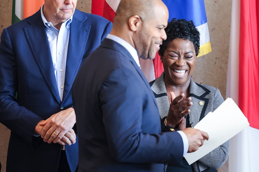 Dallas city manager Kimberly Bizor Tolbert (back center) cheers as mayor Eric Johnson takes...