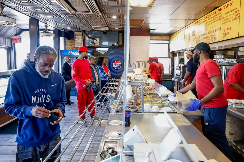 A customer prepares to pay for his meal as other customers order during the lunch hour at...