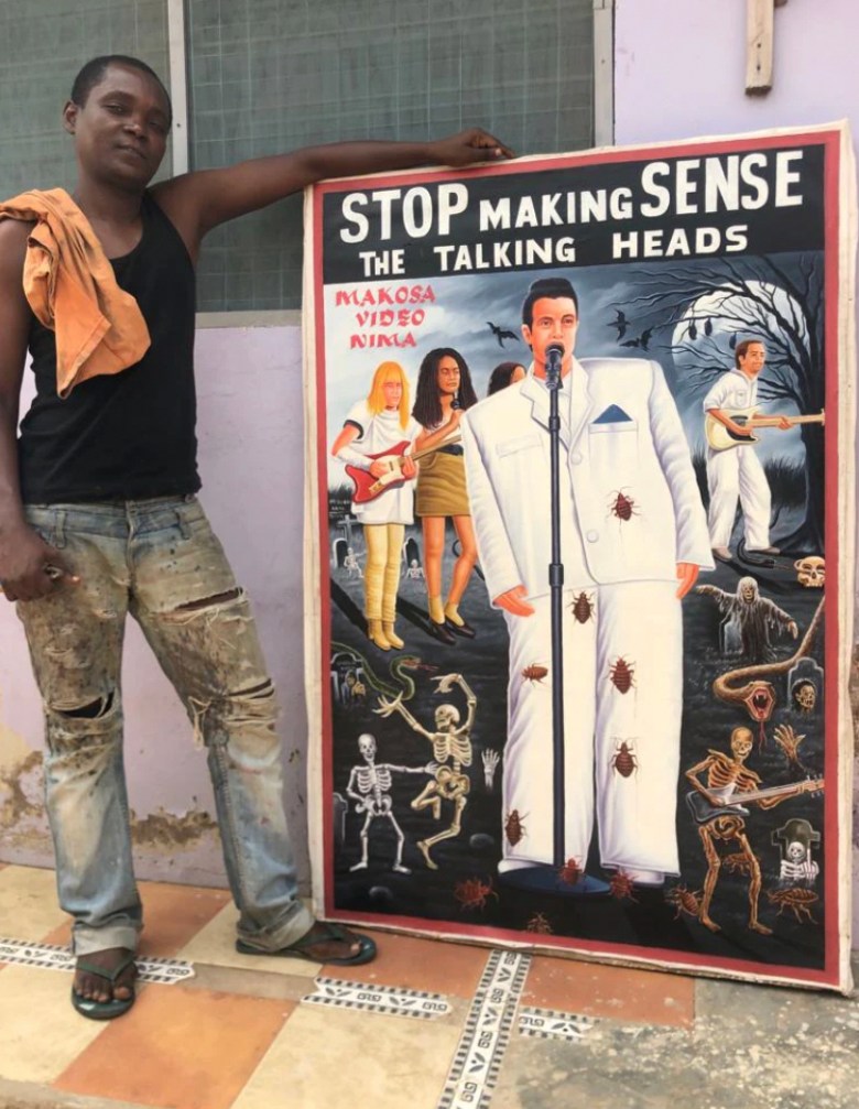 Artist Nana Agyq shows off a hand-painted poster for the Talking Heads concert movie Stop Making Sense.
