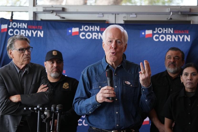 Sen. John Cornyn, R-Texas, with former Texas Gov. Rick Perry, left, speaks during a campaign...