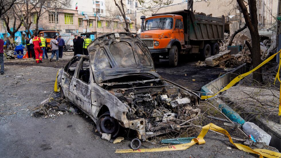 A damaged car remains on the ground in the aftermath of an Israeli-U.S. strike in Tehran,...