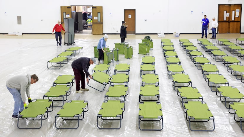 Volunteers set up a few hundred cots for those seeking shelter in the Plano Overnight...