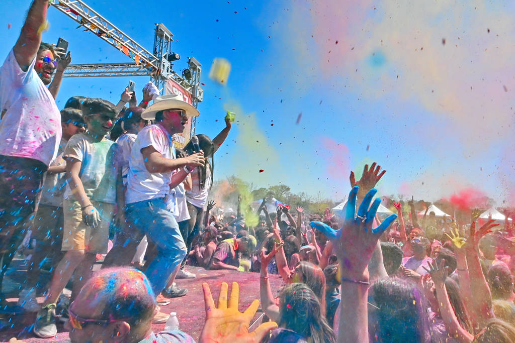 Image shows a band performing on stage at Holi Houston