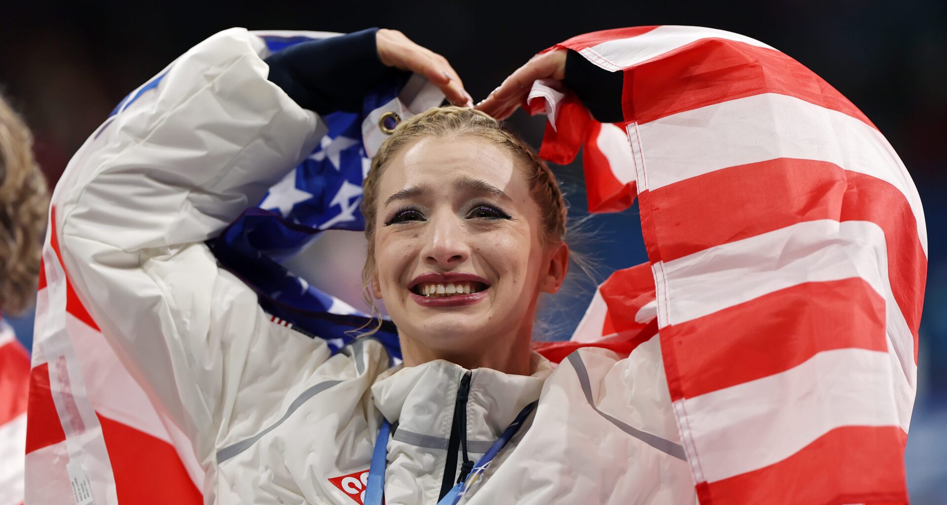 MILAN, ITALY - FEBRUARY 08: Gold medalist Amber Glenn of Team United States acknowledges the crowd following the Medal Ceremony for the Team Event after the Men