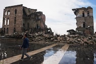 A man walks past a building that was destroyed during the civil war in the Old City of...