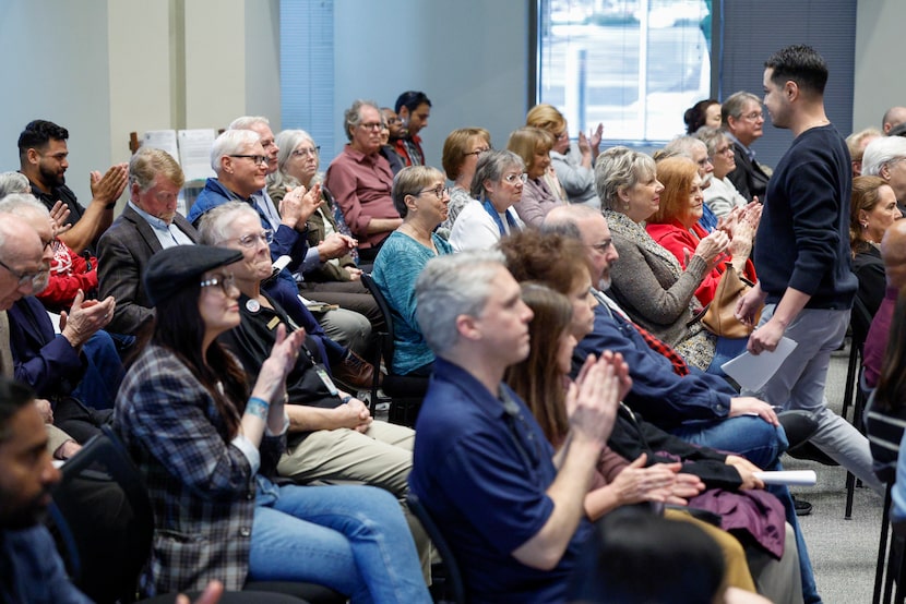 Farmers Branch resident Christian Gomez, 31, walks back to his seat as attendees applaud him...