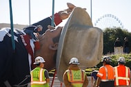 Tim Thibodeaux, who works for Midway Operations, unties Big Tex’s scarf after the State Fair...