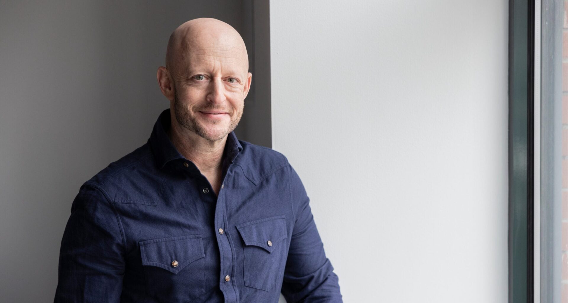 Man in navy shirt against gray wall