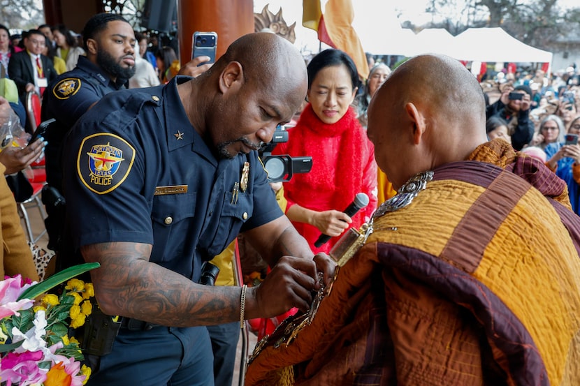 Fort Worth police commander A.J. Williams pins a badge to Bhikkhu Pannakara during a...
