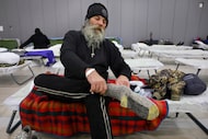 Michael Baker, an unhoused client, pulls on a clean set of wool socks after taking a hot...