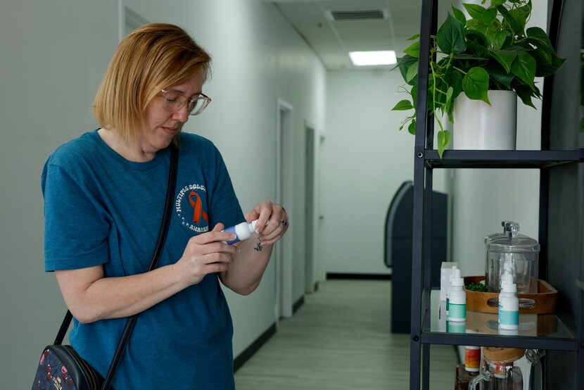 Leslie Lewis of Plano checks out a bottle of CBD and THC tincture oil at Goodblend medical...