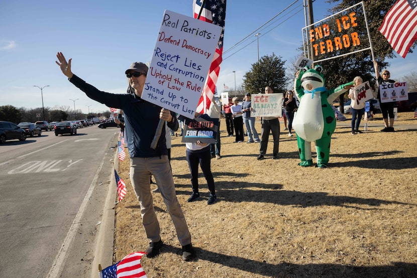 Jim Berry (left) of Allen holds a sign while protesting during a No Kings and anti-ICE...