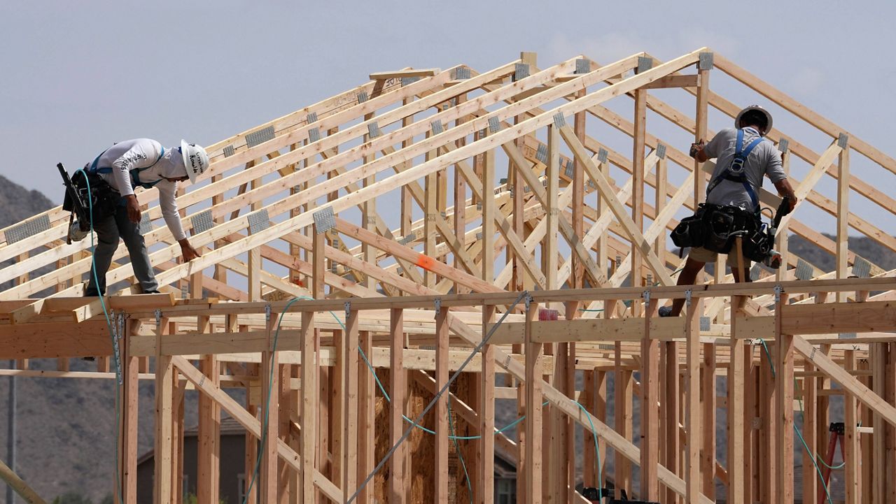 Construction workers frame up a roof of wood lumber at a new home build, April 1, 2025, in Laveen, Ariz. (AP Photo/Ross D. Franklin)