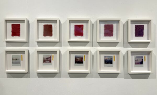 An artwork in two rows of five framed pieces, the op row featuring strips of red cloth, with Polaroid photographs of landscapes in the bottom row.