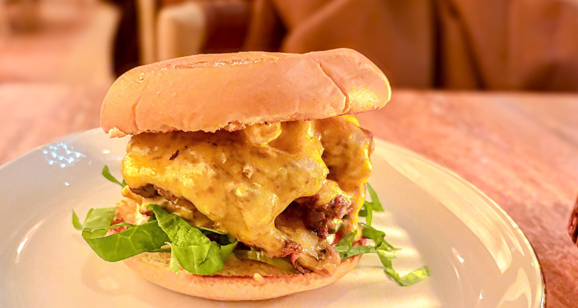 A Little Ruby's Burger sitting on a plate on a table