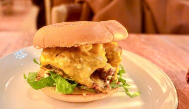 A Little Ruby's Burger sitting on a plate on a table