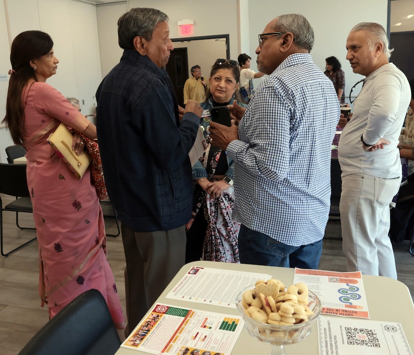 Chanda Parbhoo (center, background) listened as Harry Sutaria (center left) and KB Savalia...