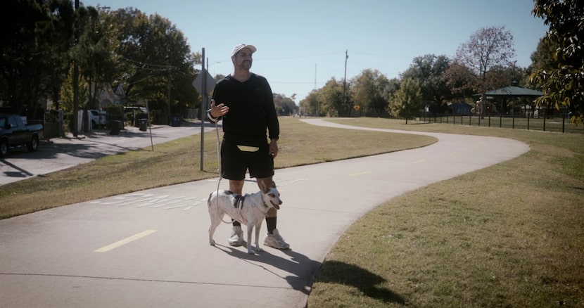 Dallas artist Antonio Lechuga and his dog, Chanclas, stand near where the artist was shot on...