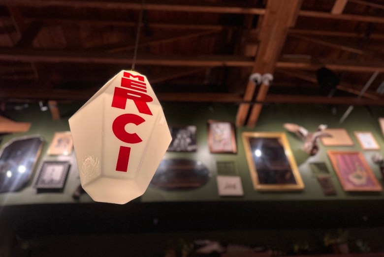 Custom lanterns stamped with bold red lettering hover overhead at the new nightspot.