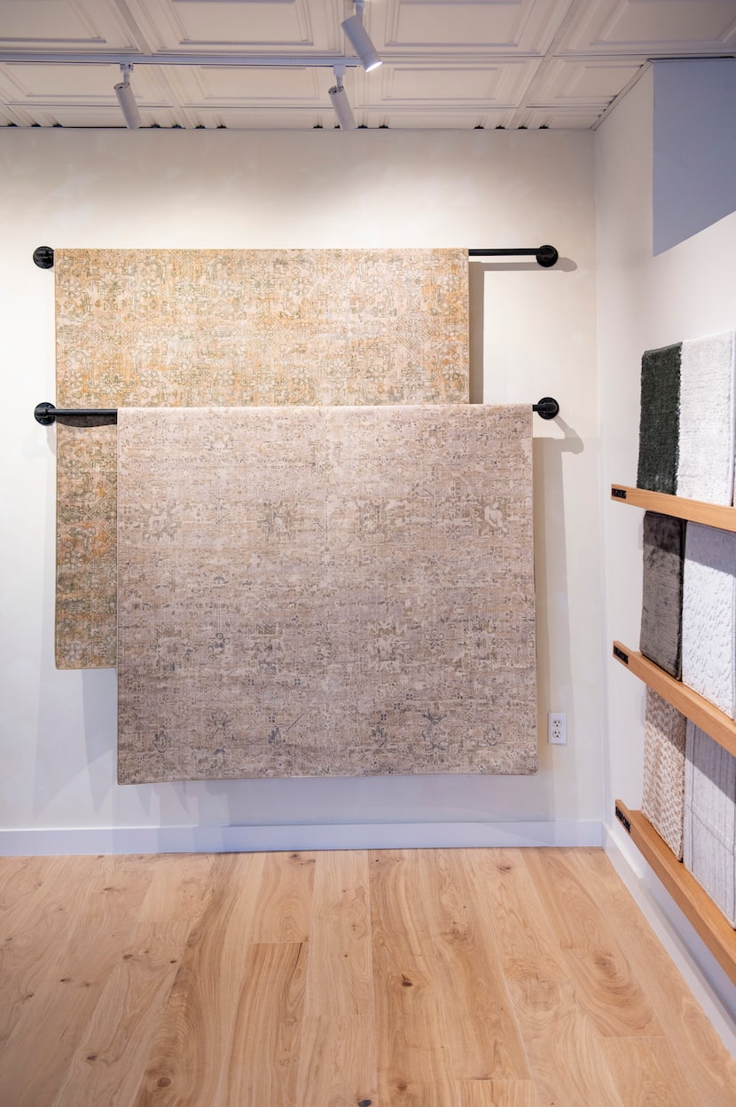 Rug samples draped over rods in a showroom