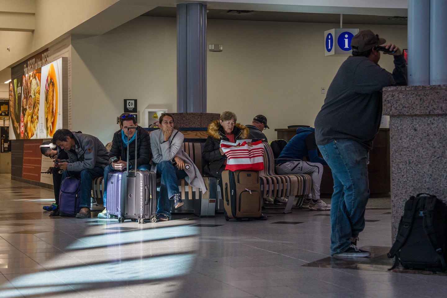 Passengers wait on benches after an abrupt closure and reopening of El Paso International Airport in El Paso.