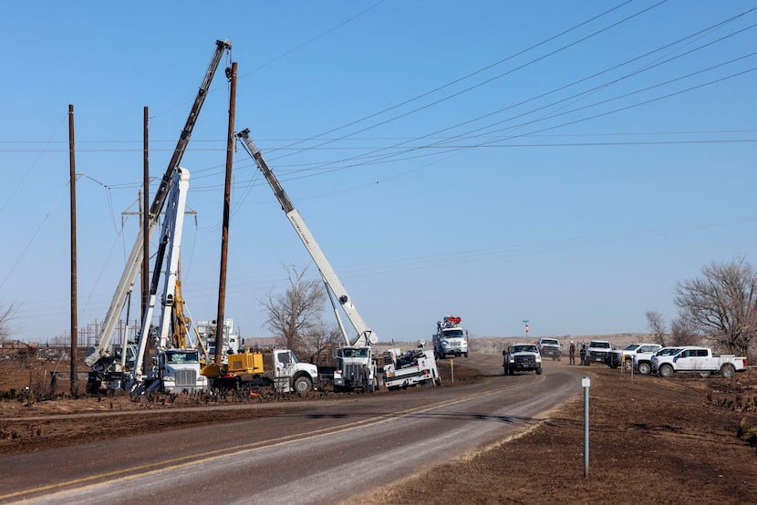 Crews work to raise utility poles and reconnect power lines after the Smokehouse Creek Fire,...