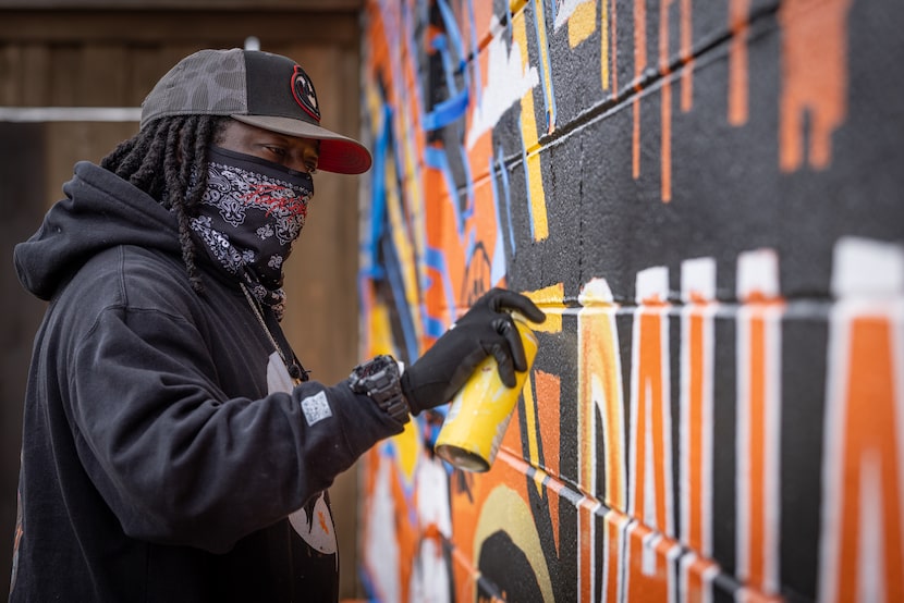 South Dallas artist Theo Ponchaveli paints a new mural depicting the words “Welcome to Sunny...