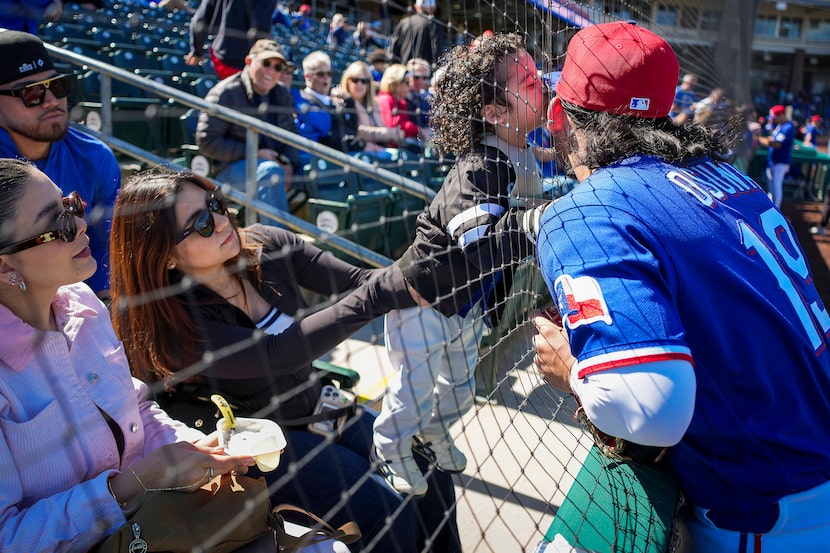 Texas Rangers outfielder Alejandro Osuna gets a kiss from his nephew Roberto Osuna before a...