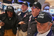 Trader Joel Lucchese, right, and colleagues wear "DOW 50,000" caps on the floor of the New...