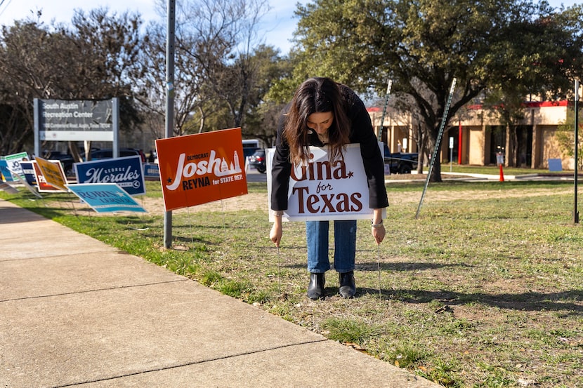 State Rep. Gina Hinojosa, a democrat candidate for governor, places a campaign sign outside...