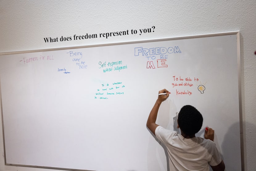 Mikelan Chambers, 13, signs his name next to his response to the question “What does freedom...