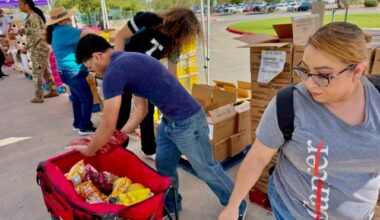 Sonia Rivera, right, gets food items loaded onto her cart by volunteer bel Ochoa Wednesday