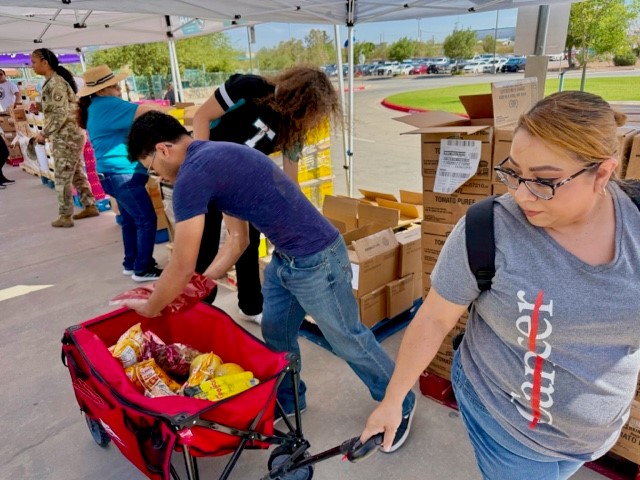 Sonia Rivera, right, gets food items loaded onto her cart by volunteer bel Ochoa Wednesday