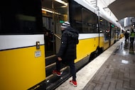 A passenger boards a DART train in the rain at Pearl/Arts District Station, Friday, Jan. 23,...