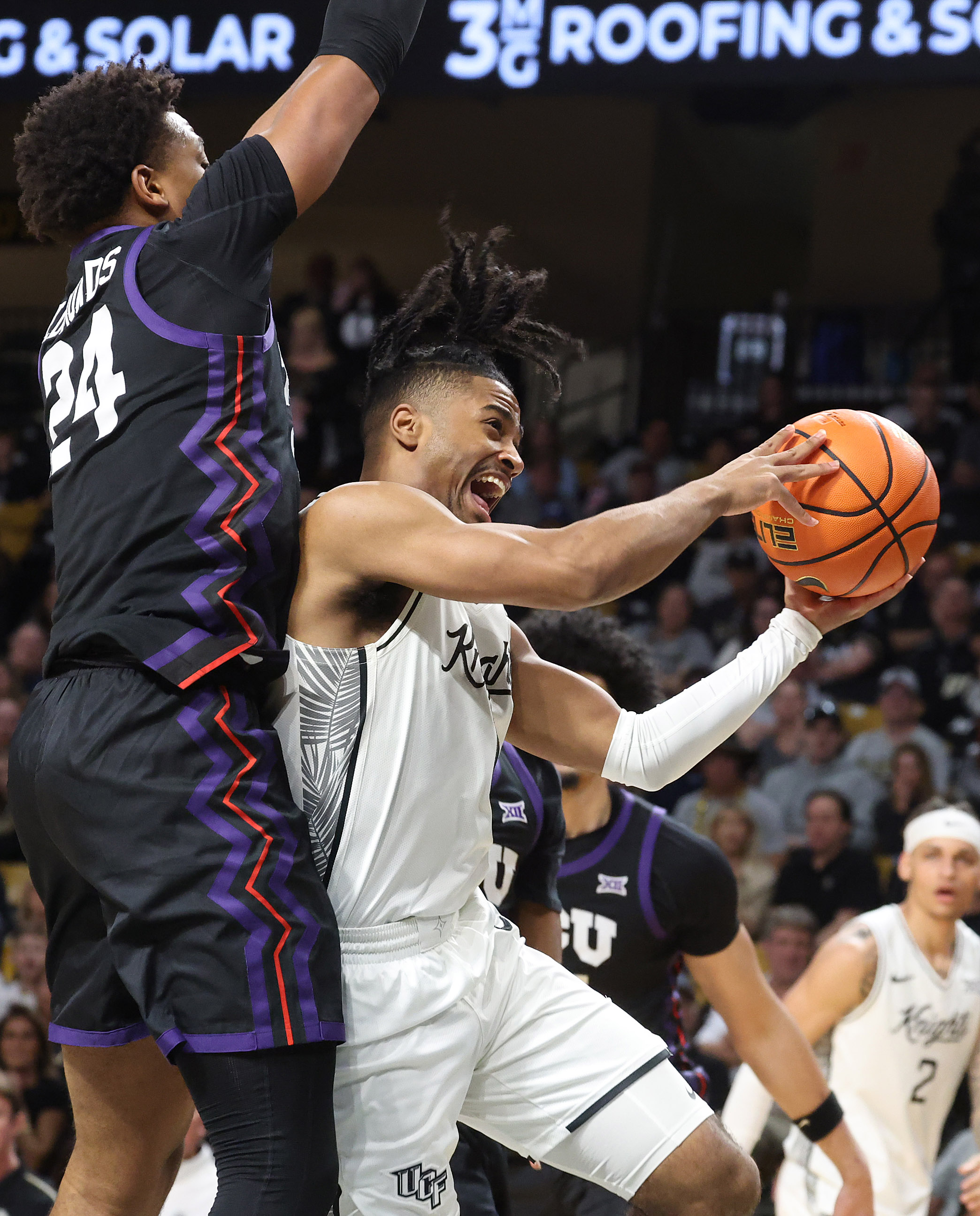 UCF guard Themus Fulks (1) scores past TCU forward Xavier...
