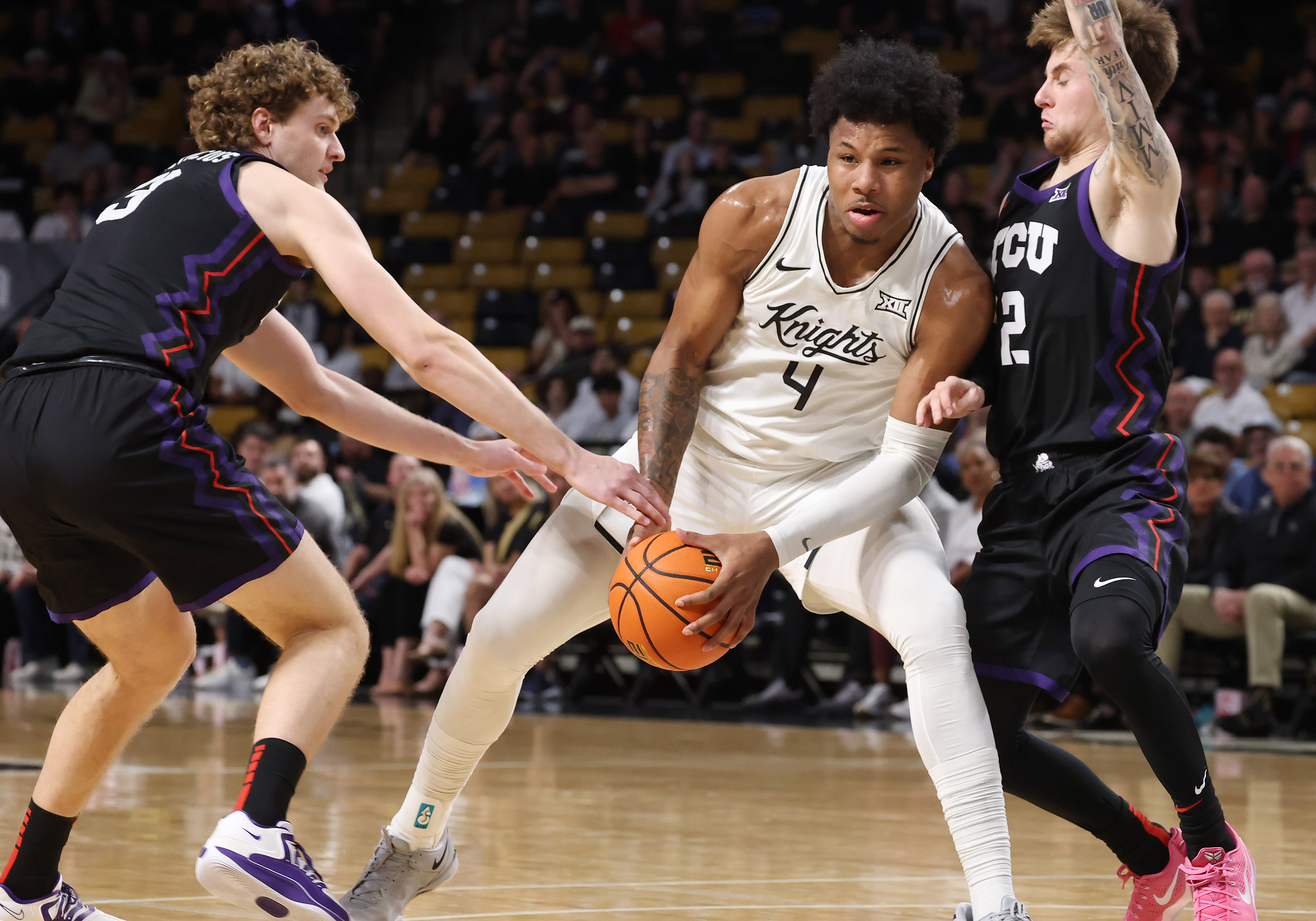 UCF forward Jamichael Stillwell (4) hangs on to the ball...