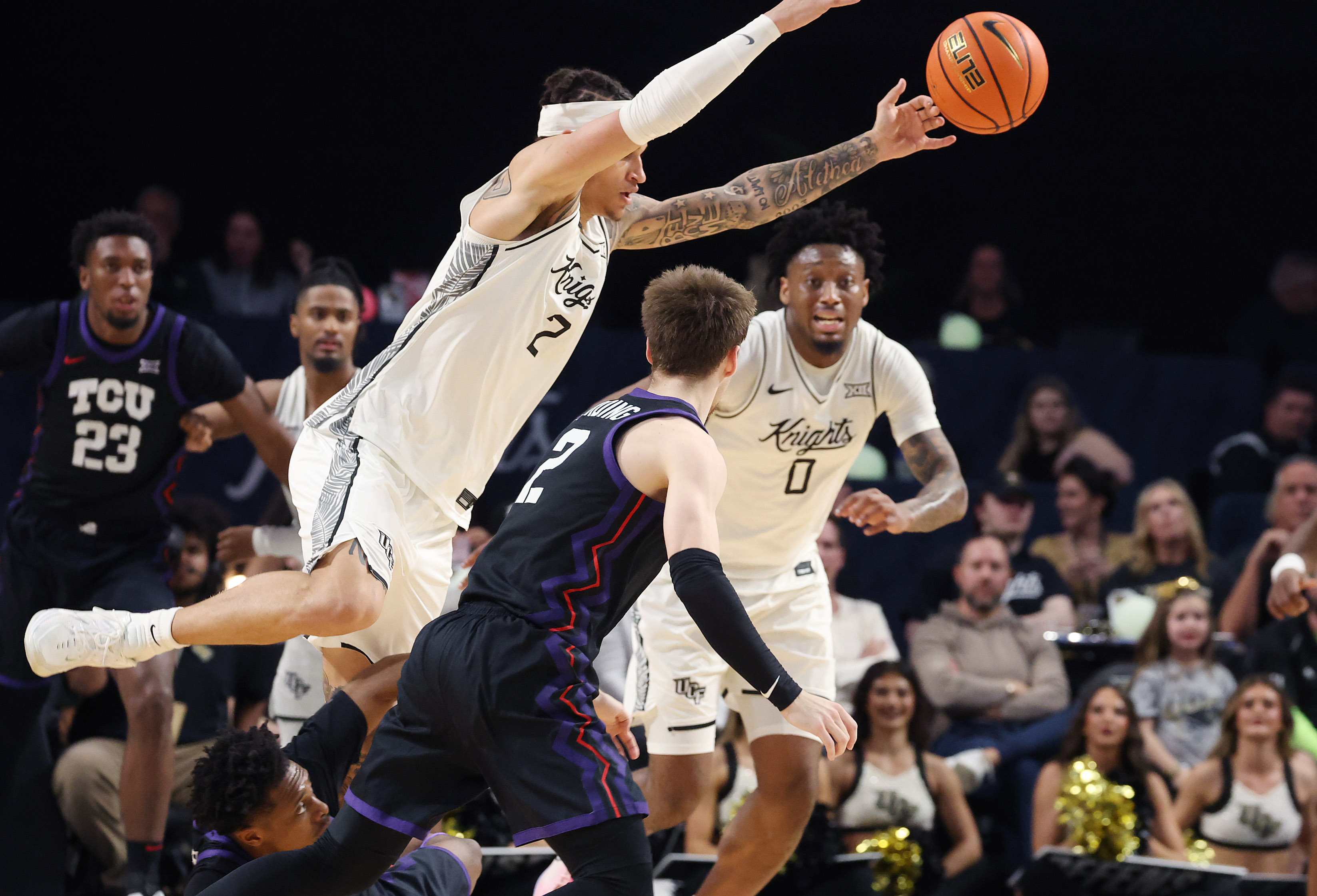 UCF guard Riley Kugel (2) leaps over players going after...