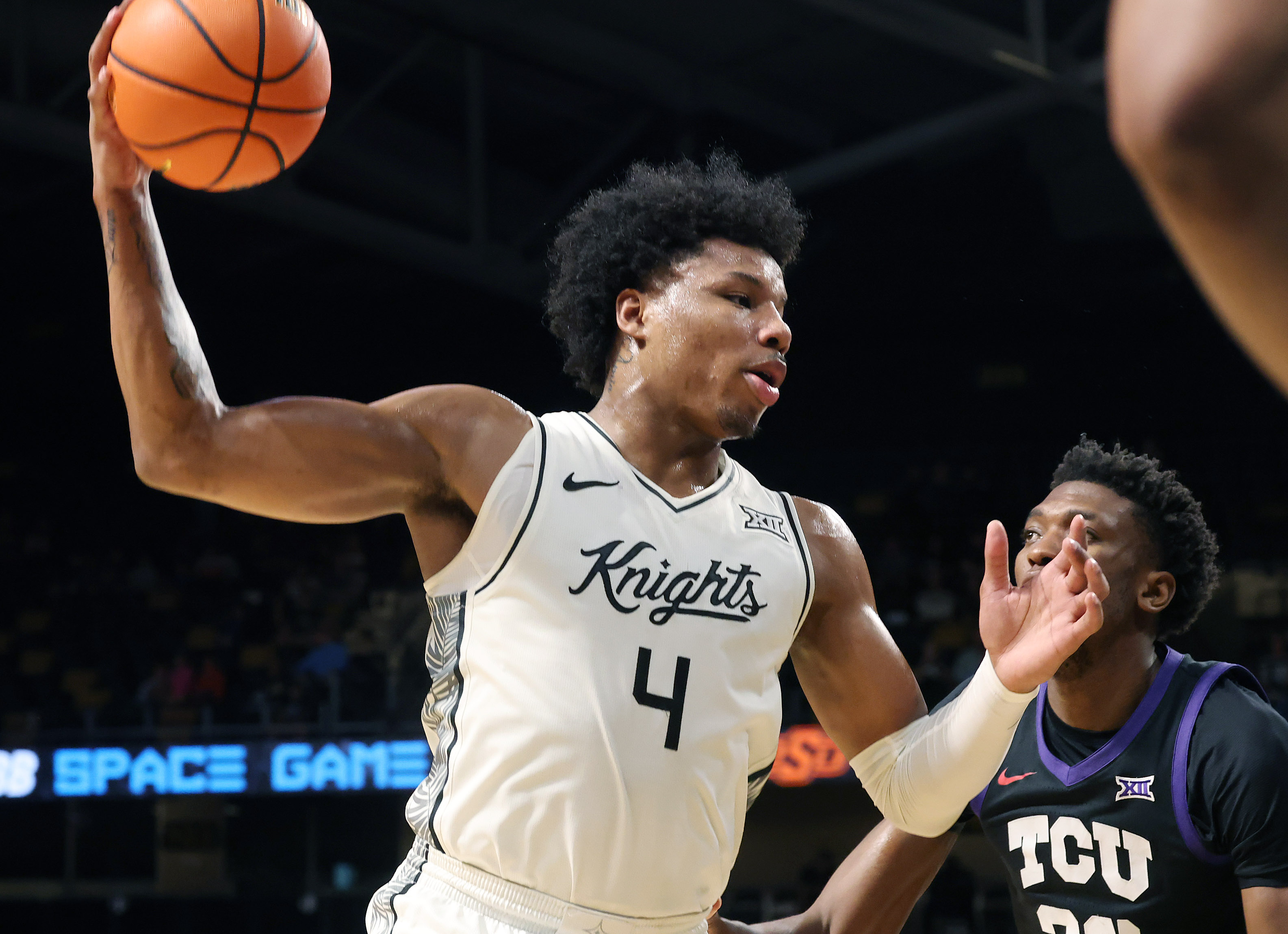 UCF forward Jamichael Stillwell (4) looks to pass beside TCU...