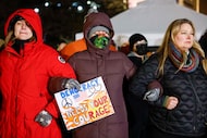 Demonstrators lock arms during a moment of silence for Renee Good and Alex Pretti during a...