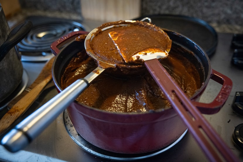 Chef Anastacia Quiñones-Pittman strains mole into a cast-iron.