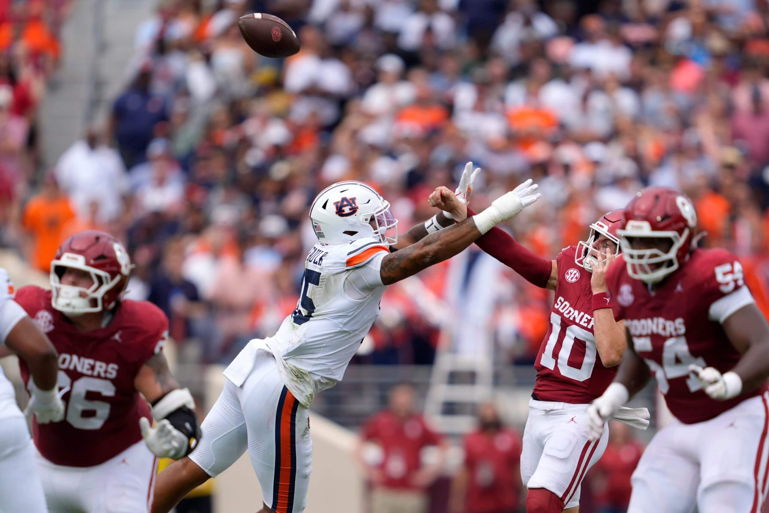 Oklahoma Sooners quarterback John Mateer (10) is hit by Auburn Tigers defensive end Keldric Faulk (15) as he throws in the first quarter in Norman, Okla., Saturday, Sept. 20, 2025.