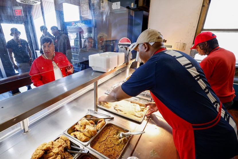  Isaiah Williams places a tray of turkey wings on the line during the lunch rush at Sweet...