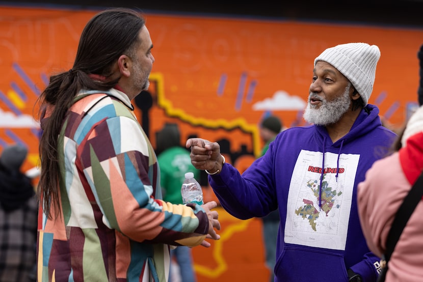 Casey Phillips (left), CEO of The Walls Project, speaks to building owner Traswell...