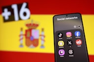 A Spanish flag, smartphone with displayed social media app icons. (photo illustration)
