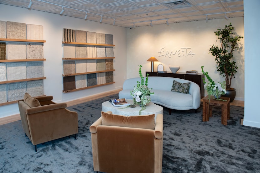 Showroom with couch and chair seating and a wall or rug samples