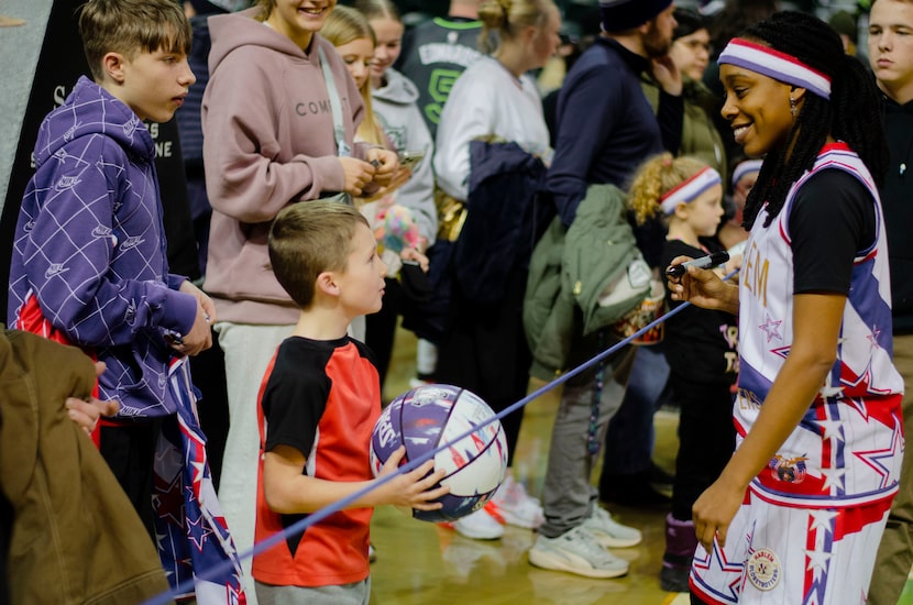 A member of the Harlem Globetrotters signs autographs for fans. The team will come to North...