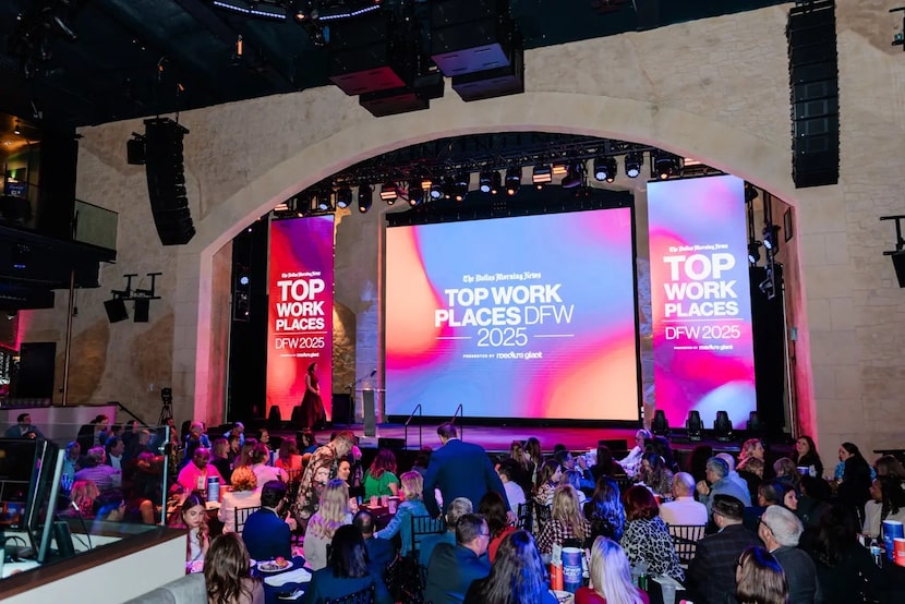 Event with numerous tables set up in front of a stage