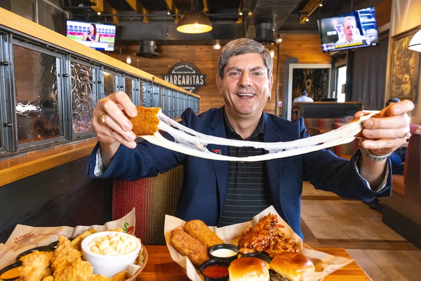 Man holding a cheesy appetizer