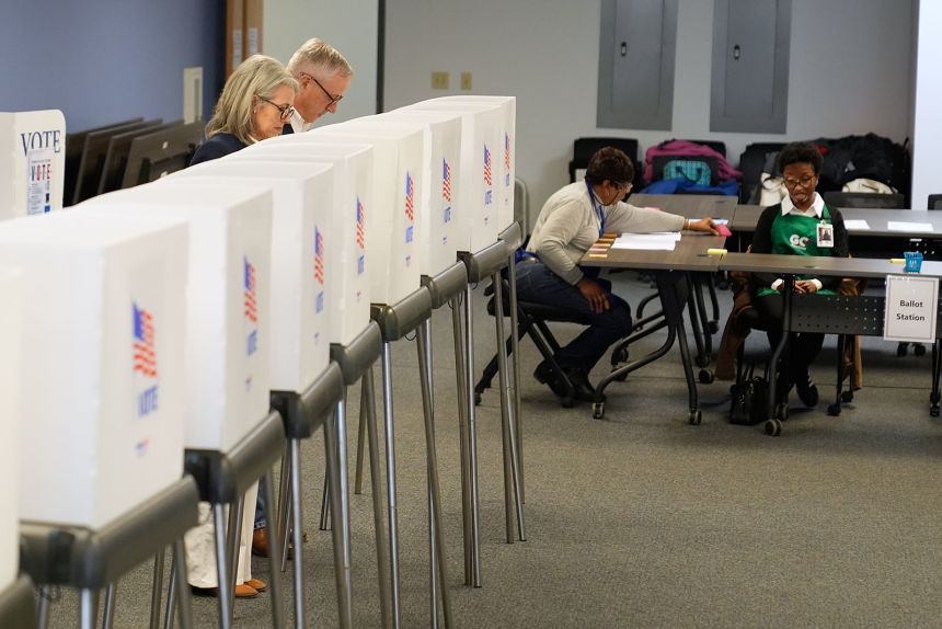 Republican US Senate candidate Michael Whatley, second from left, and his wife Suzanne cast their votes at an early voting site on February 12, in Gastonia, North Carolina.
